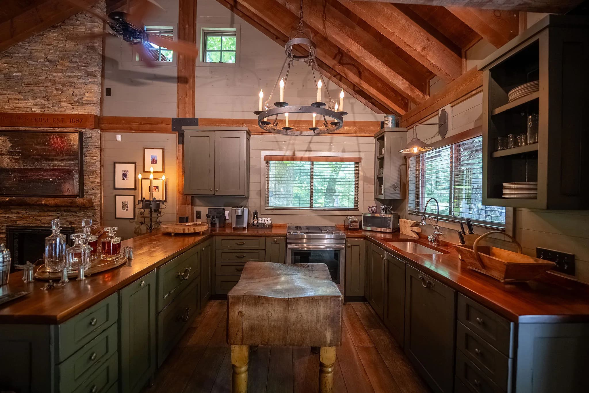 Sage green kitchen with antique butcher block island in a South Carolina cabin